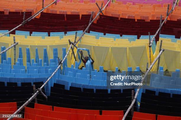 Worker is drying fabric after a dyeing process at a factory in Narayanganj, Bangladesh, on May 16, 2024.