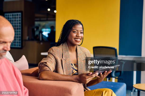 smiling african american businesswoman in a plaid blazer holding a tablet in a modern office. empowerment and professional growth in business concept - estilista de moda ocupação criativa imagens e fotografias de stock