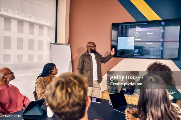 gemischtrassiges geschäftsteam in einem meeting mit datenanalysepräsentation in einem modernen büro. unternehmensstrategie und analysekonzept - bildschirmpräsentation stock-fotos und bilder