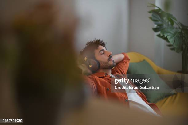 moment of calm and tranquility. enjoying his favorite music. - muziekstreamingdienst stockfoto's en -beelden