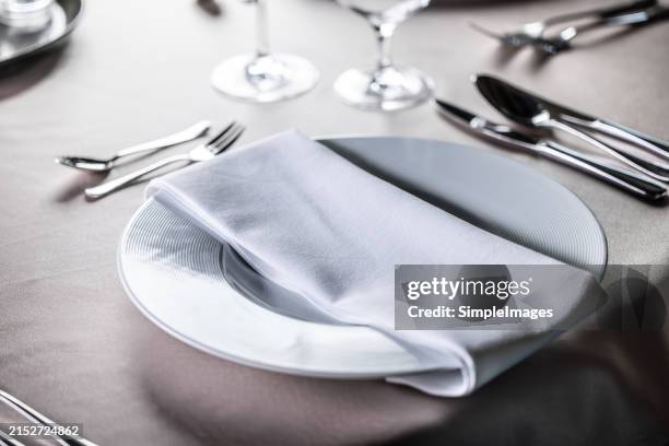 luxurious interior, white tables, serving dishes and glasses for guests. - serviette stock-fotos und bilder