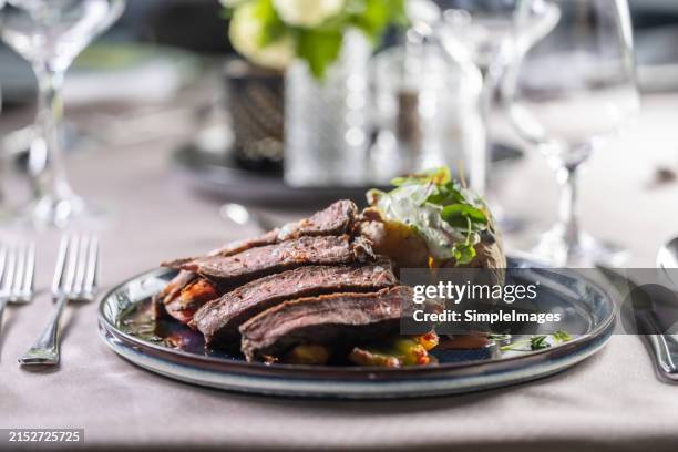 filleted beef rib eye steak served on a ceremonially prepared table in a restaurant. - rib eye steak stock-fotos und bilder