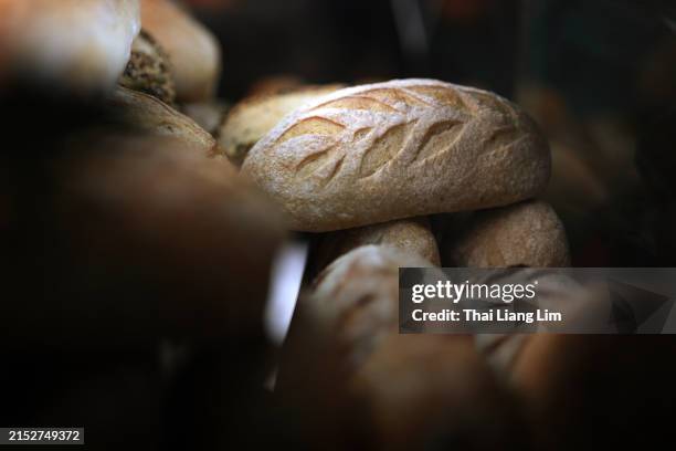 a stack of freshly baked artisan bread displayed at a stall. - ciabatta stock pictures, royalty-free photos & images