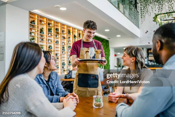 male waiter serving drinks to friends in a café - carrying table stock pictures, royalty-free photos & images
