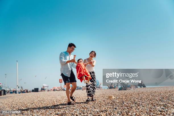 young asian family having fun on the beach - relaxation stock pictures, royalty-free photos & images