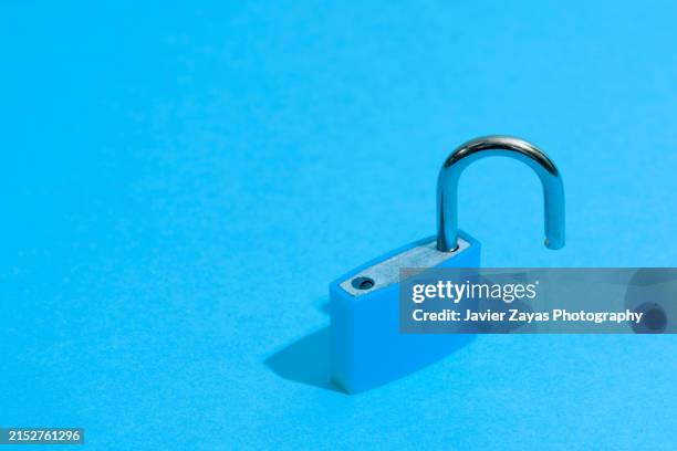 open blue padlock isolated on blue background - unlocked padlock stock pictures, royalty-free photos & images