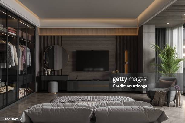 modern bedroom interior with television set, dressing table, walk in closet, armchair and rear view of double bed at night - home television cozy dark from behind stock pictures, royalty-free photos & images
