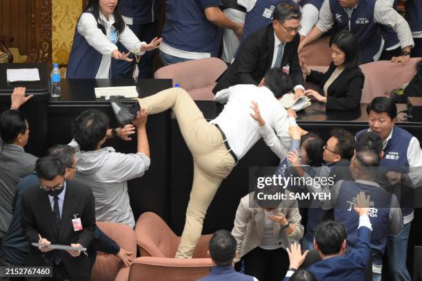 Taiwan's ruling Democratic Progressive Party lawmaker Kuo Kuo Wen tries jumping onto the desk during the voting for the Parliament reform bill at...