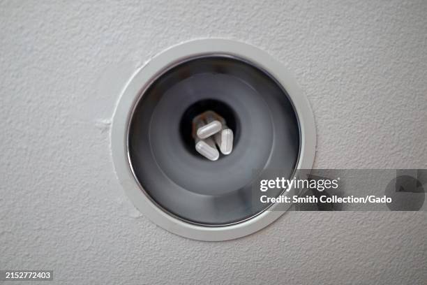 Close-up of a compact fluorescent lightbulb in a fixture on a white textured background, Newport Beach, California, April 25, 2024.