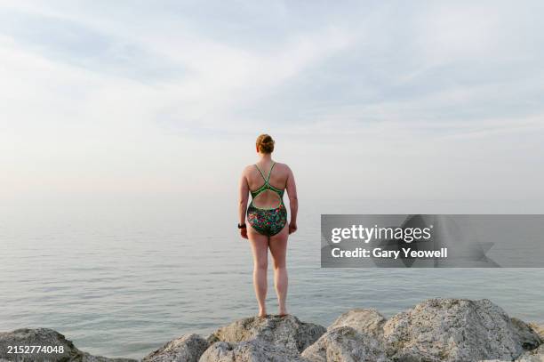 open water swimmer standing by the sea - seascape stock pictures, royalty-free photos & images