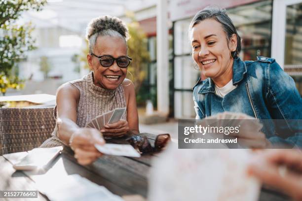 amiche anziane che giocano a carte - carte da gioco foto e immagini stock