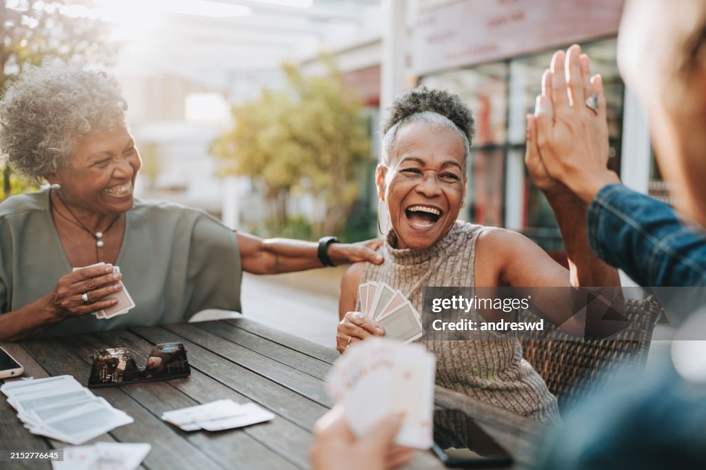 Senior women friends playing cards