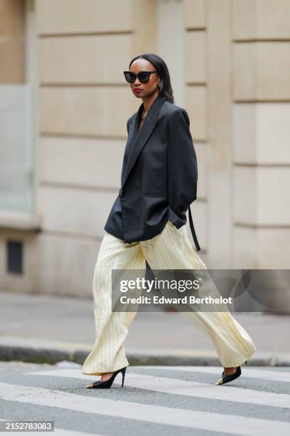 Emilie Joseph wears sunglasses, a black oversized / structured virgin wool blend blazer jacket with lapel-collar by Victoria Beckham for Mango,...