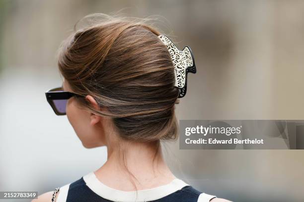 Close-up view of a black and white hair pin, during a street style fashion photo session, on May 12, 2024 in Paris, France.