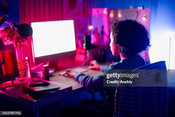 teenage boy surfing the net on his computer - mens en machine stockfoto's en -beelden