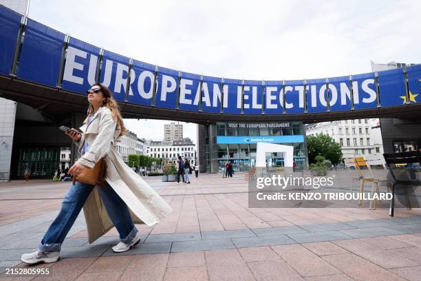 Pedestrian walks past a banner displayed on the building of the European Parliament in Brussels, on May 17 ahead of the European elections scheduled...