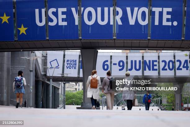 Pedestrian walk past a banner displayed on the building of the European Parliament in Brussels, on May 17 ahead of the European elections scheduled...