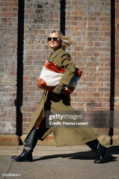 Violet Grace wearing khaki coat, oversized tote and black boots during Australian Fashion Week Presented By Pandora 2024 at Carriageworks on May 14,...