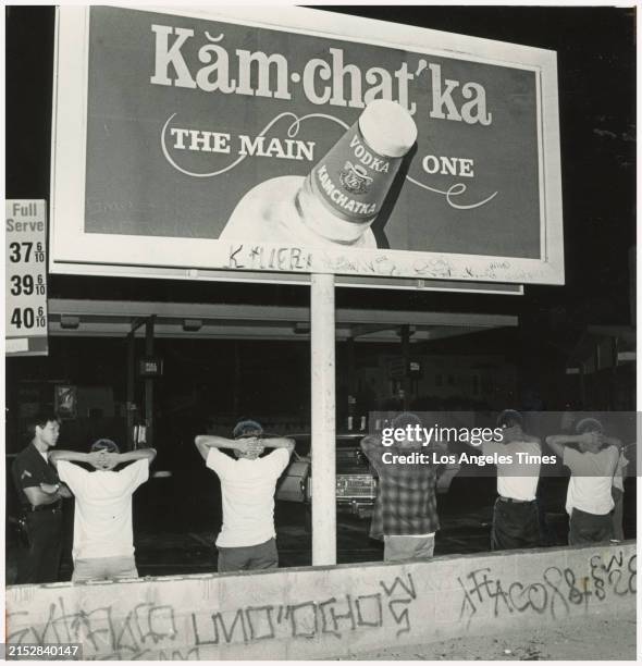 18th Street gang members were searched for weapons, next to graffiti covered walls at 54th and Main Streets in Los Angeles, CA., on July 27, 1981....