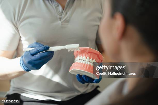 doctor explaining technique for teeth cleaning. female patient at dentist. dentists examination and dental hygiene in modern ambulance. - sbiancamento dentale foto e immagini stock