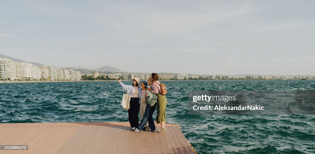 Group of female friends taking a selfie while on a city break