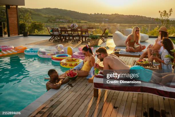 plano general de la gente relajándose junto a la piscina - fiesta de piscina fotografías e imágenes de stock