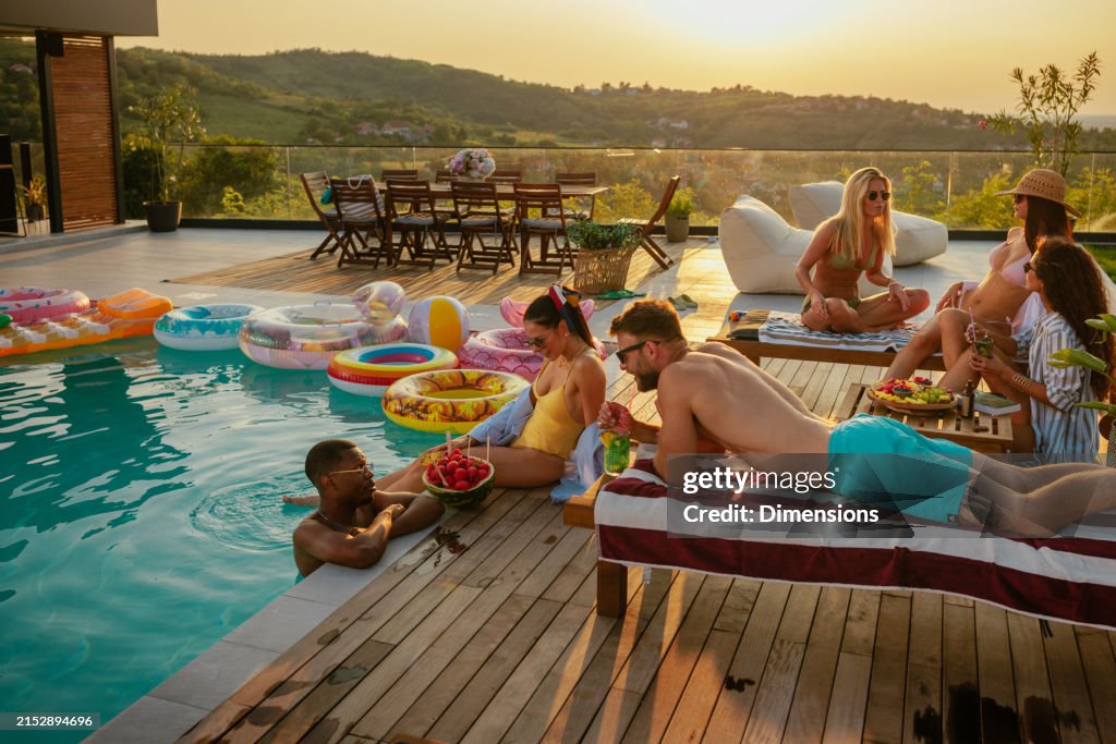Wide shot of people chilling by the pool