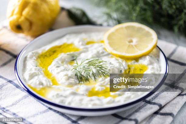 greek dip sauce or dressing tzatziki prepared with grated cucumber greek yogurt, olive oil, dill lemon juice and fresh dill. - joghurtsoße stock-fotos und bilder