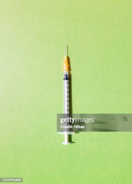 syringe on green background - hepatitis fotografías e imágenes de stock