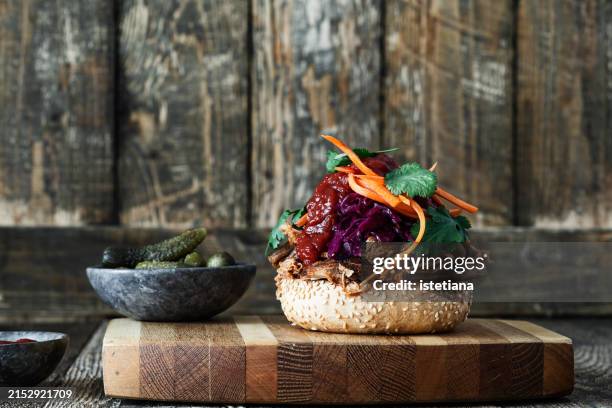 pulled pork sandwich with bbq sauce and bright slaw, and pickles - gegrilltes schweinefleisch stock-fotos und bilder
