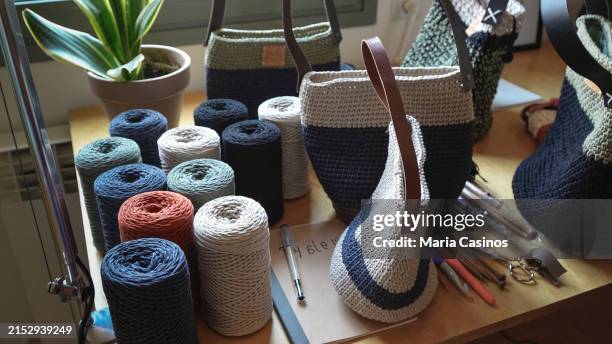 workshop table with tools, spools of threads and handmade bags - crochet imagens e fotografias de stock
