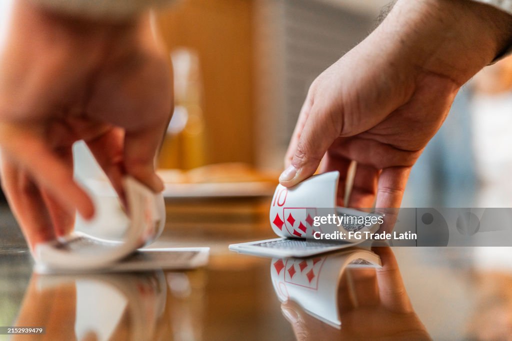 Close-up of man shuffling the cards on cards game at home