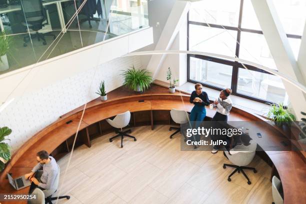 colleagues having coffee brake and chatting at the office - comfortabel stockfoto's en -beelden