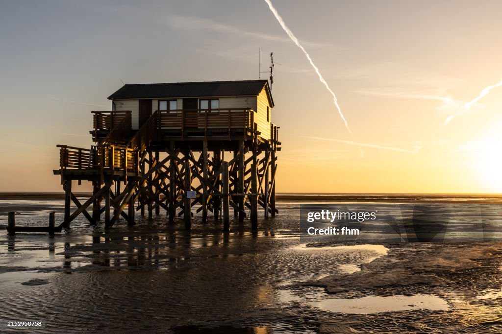 Travel destination: Stilt house on the beach in St. Peter Ording at sunset (Schleswig-Holstein, Germany)
