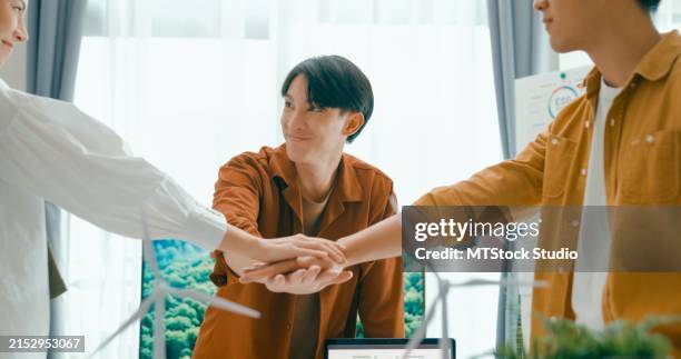 diverse team unites hands over desk with renewable energy models, symbolizing cooperation and agreement on sustainable business practices.eco-friendly business team discussing esg goals. - responsibility stock pictures, royalty-free photos & images