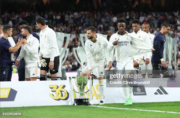 Real Madrid players interact with the La Liga trophy prior to the LaLiga EA Sports match between Real Madrid CF and Deportivo Alaves at Estadio...