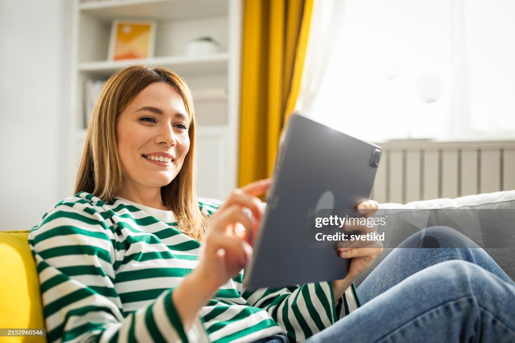 Jeune femme à l'aide de tablette numérique à la maison