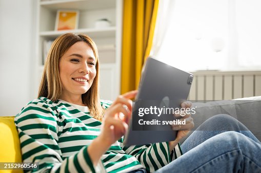 Young woman using digital tablet at home Young woman using digital tablet at home