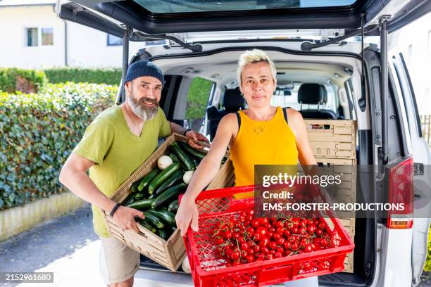 food sharing team are packing rescued food in car trunk - initiative photos et images de collection