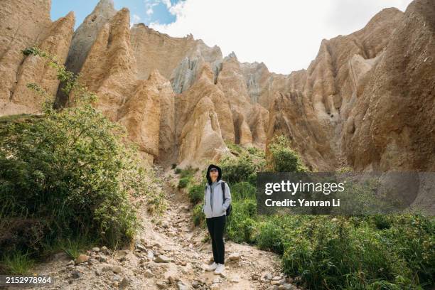 asian female tourist standing in the valley of clay cliff and looking up - clay stock pictures, royalty-free photos & images