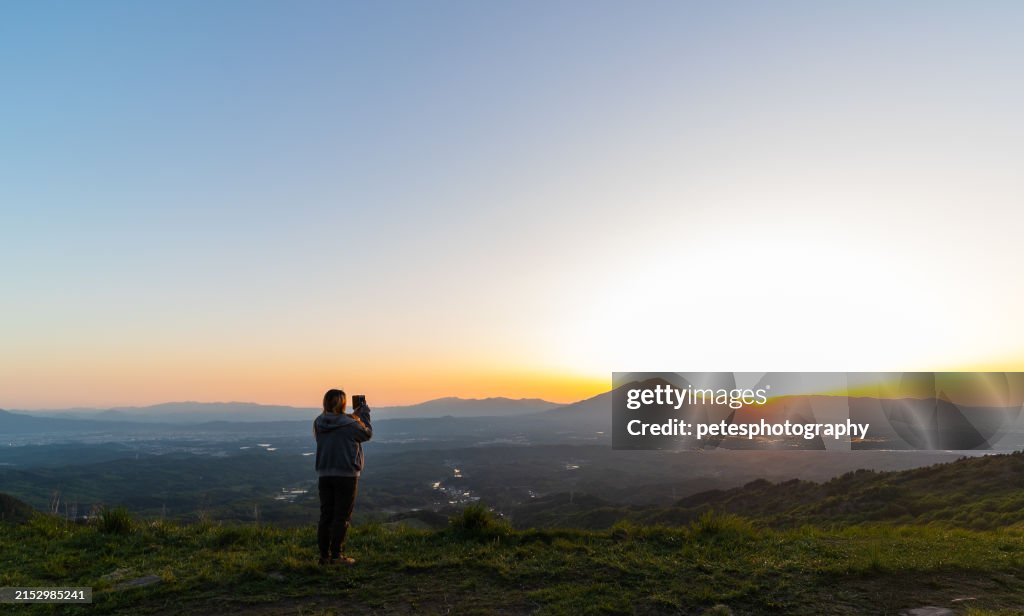 Tourist taking photo of Mt. iwate sunset with mobile phone