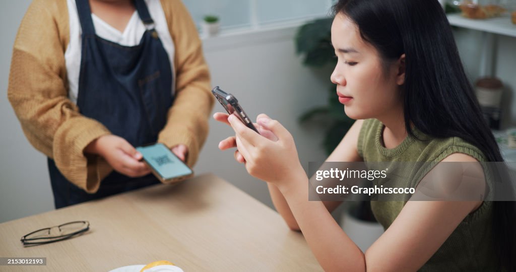 Young Girl Pays Using A Phone App In A Restaurant High Res Stock Photo Young Girl Pays Using A Phone App In A Restaurant High Res Stock Photo