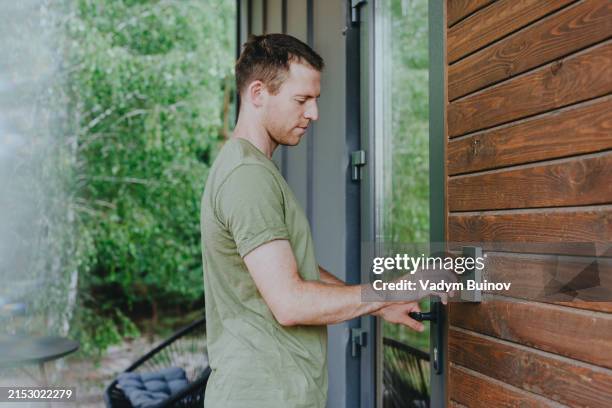 young man entering password code on door digital combination lock - pin entry stock pictures, royalty-free photos & images