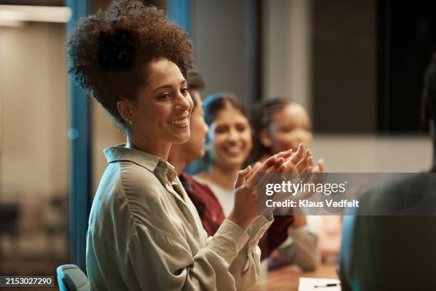 smiling colleagues clapping and applauding during meeting - applaudire foto e immagini stock