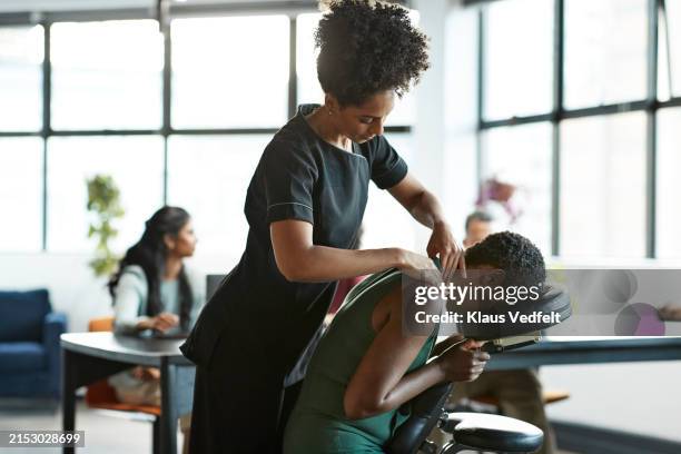 masseuse pampering exhausted businesswoman with massage - body care and beauty stock pictures, royalty-free photos & images