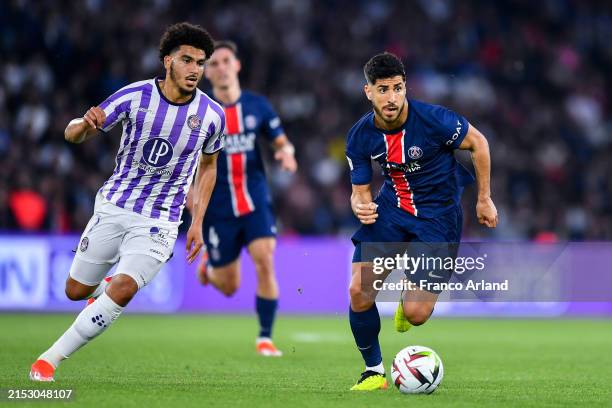 Marco Asensio of PSG runs with the ball under pressure from Zakaria Aboukhlal of Toulouse during the Ligue 1 Uber Eats match between Paris...