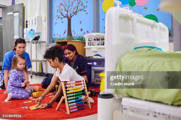 jóvenes pacientes del hospital jugando en la sala de niños - hospital infantil fotografías e imágenes de stock