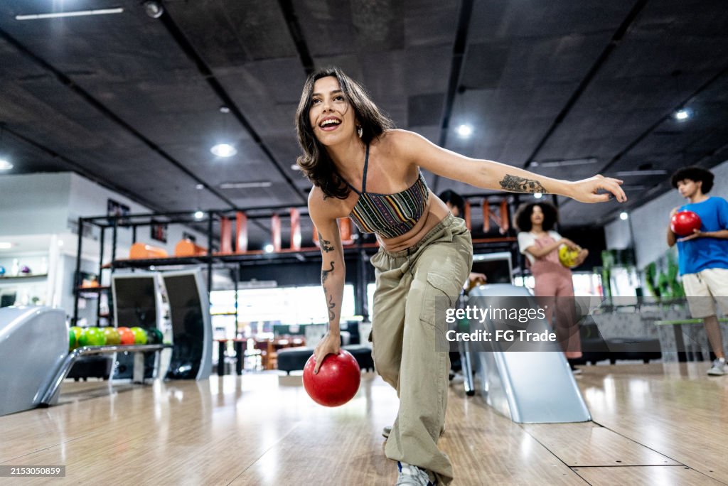 Mid adult woman playing bowling on a bowling alley