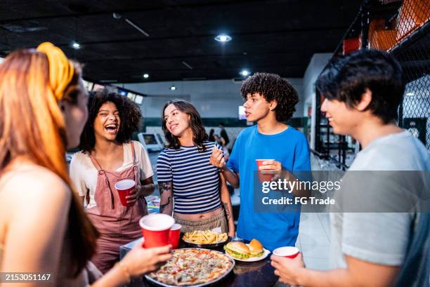 freunde essen und reden auf einer bowlingbahn - bowlingbahn stock-fotos und bilder