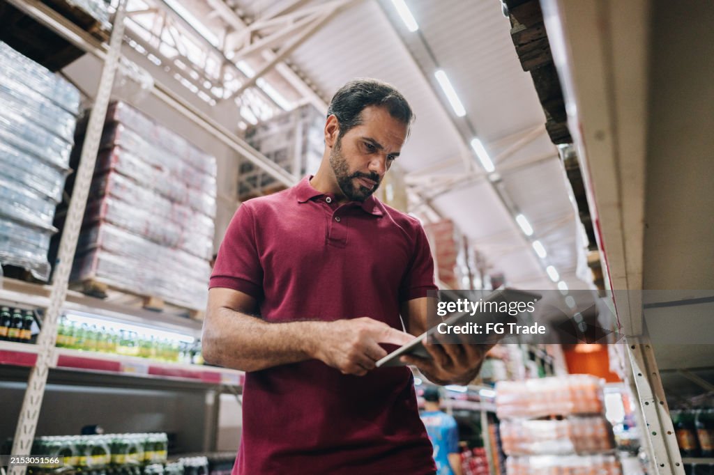 Homem maduro trabalhando no laptop no supermercado